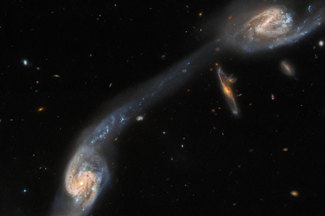 Хаббл показал две галактики, соединенные между собой огромным рукавом